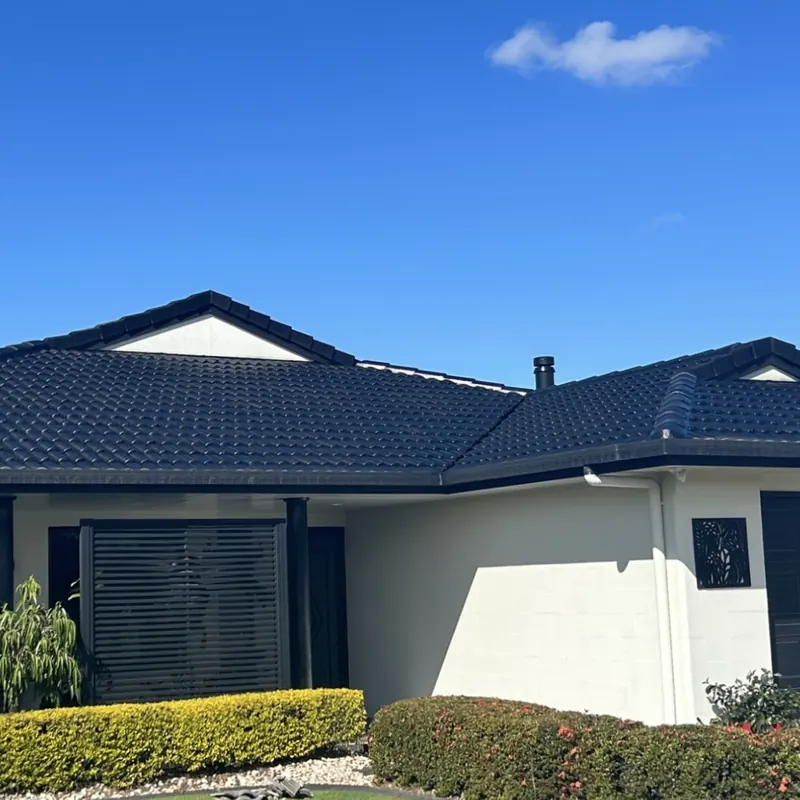 Charcoal tile roof against bright blue sky