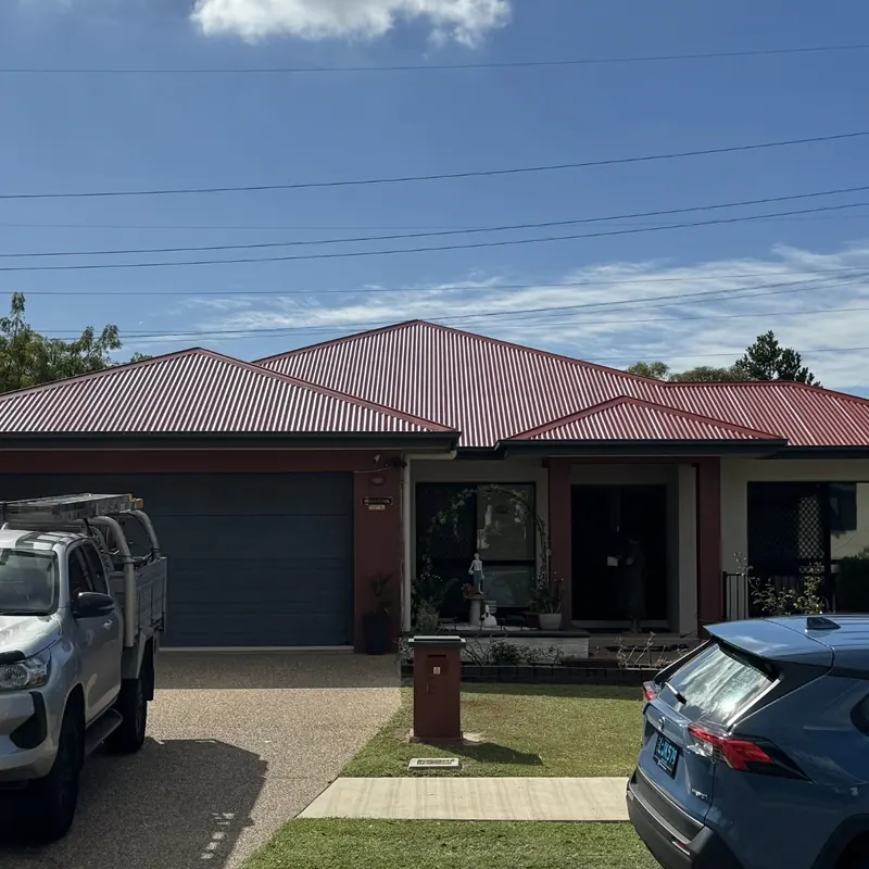 Modern home with deep red Colorbond and company truck