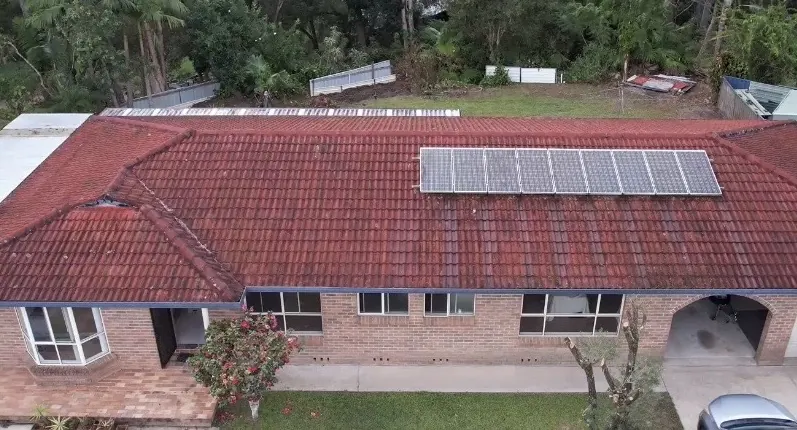 Aerial view of faded red tile roof before restoration