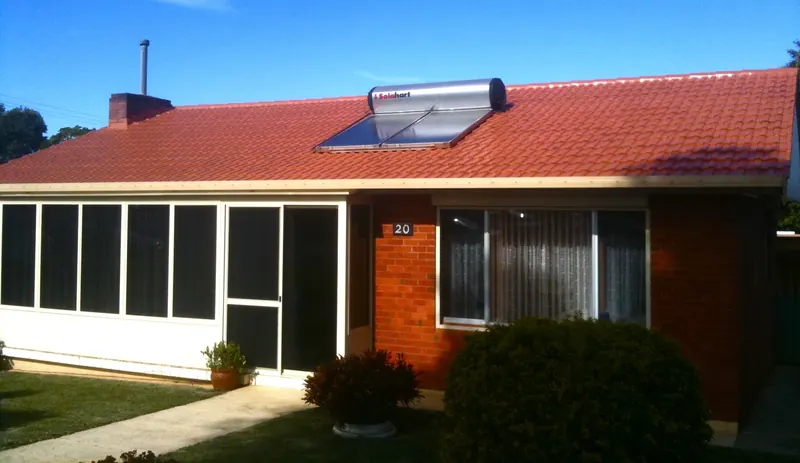 Vibrant red terracotta tile roof with solar panels